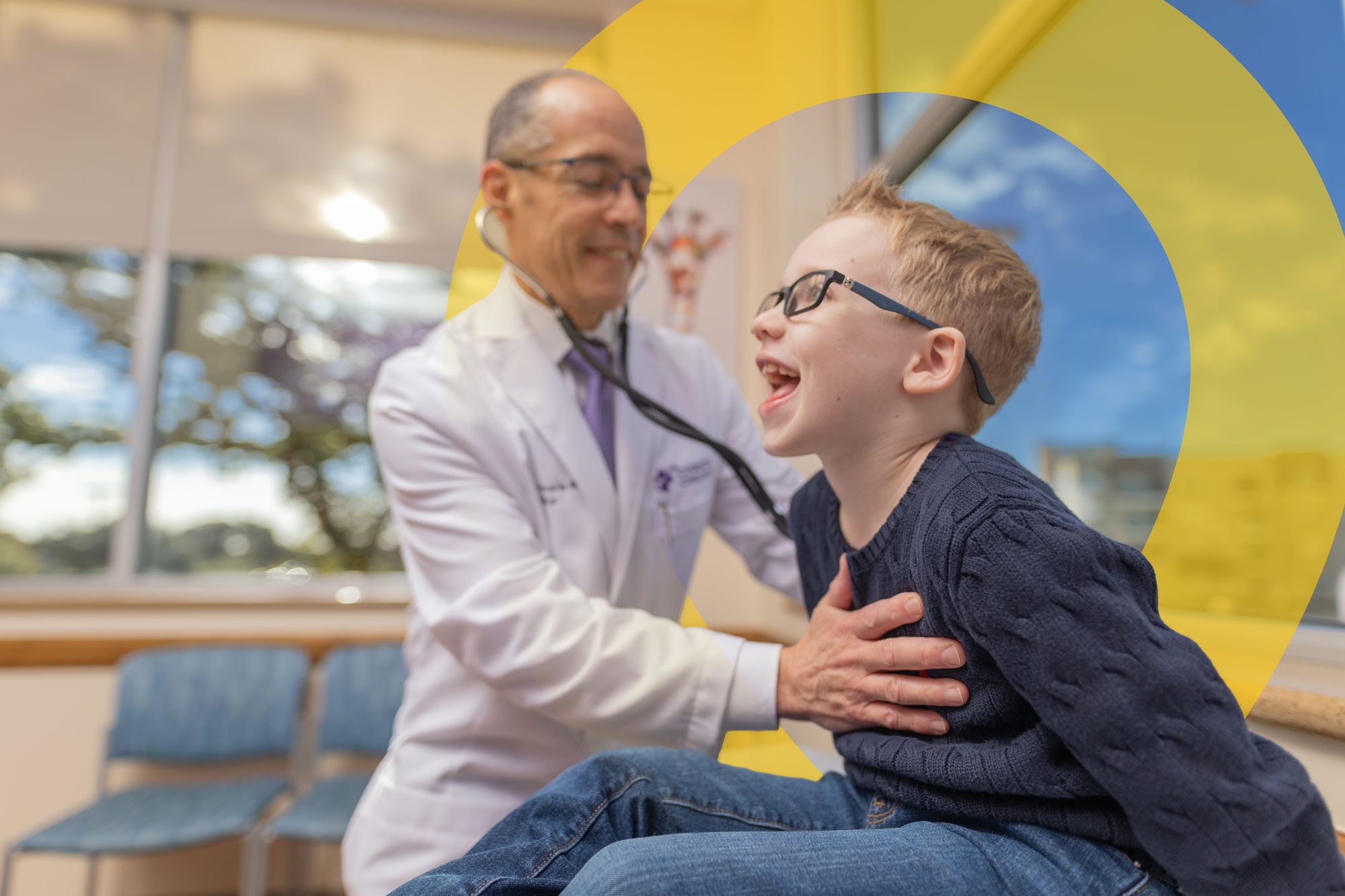 Doctor examining a smiling child during a hospital visit.